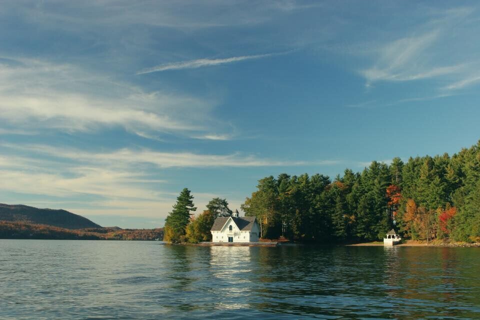 A cabin on a lake island with pine trees
