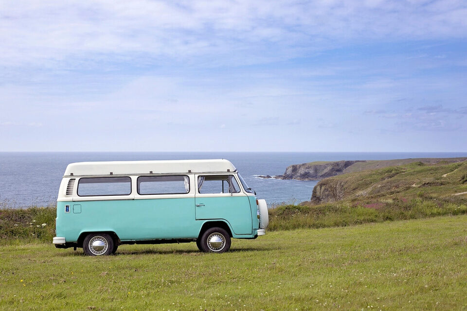A camper van parked above the sea