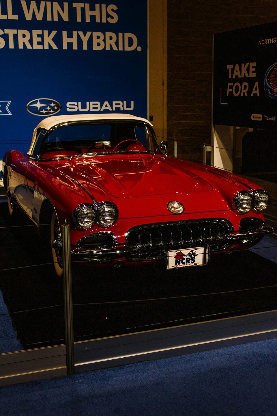 A red classic Corvette in a showroom