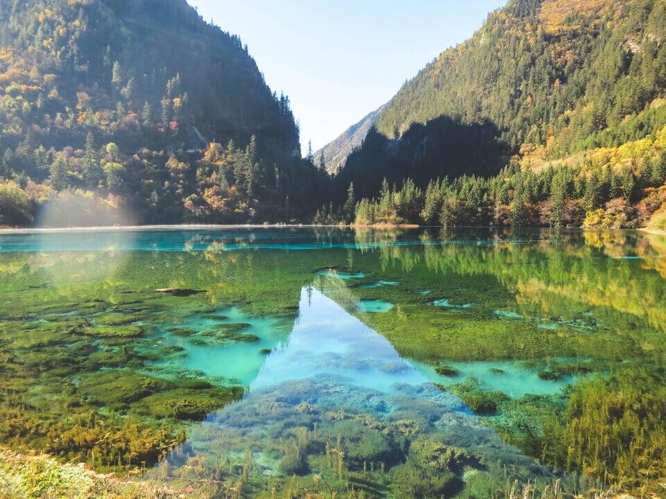 A clear mountain lake between green peaks