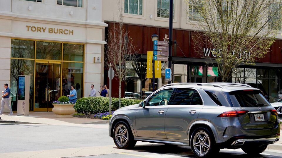 A grey Mercedes SUV on a downtown street