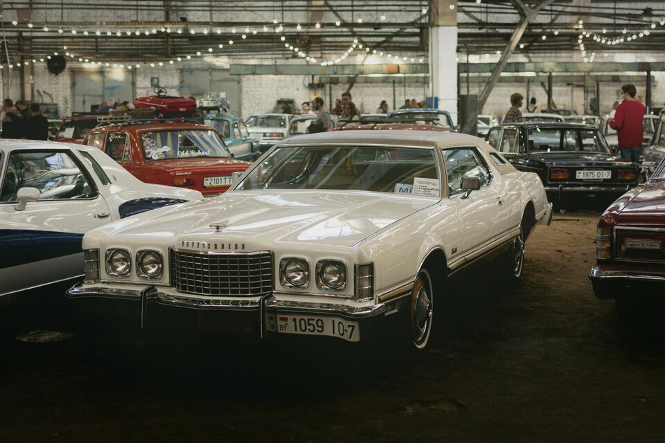 Shoppers browsing cars in an indoor showroom
