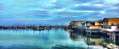 A harbor of sailboats under a bright sky