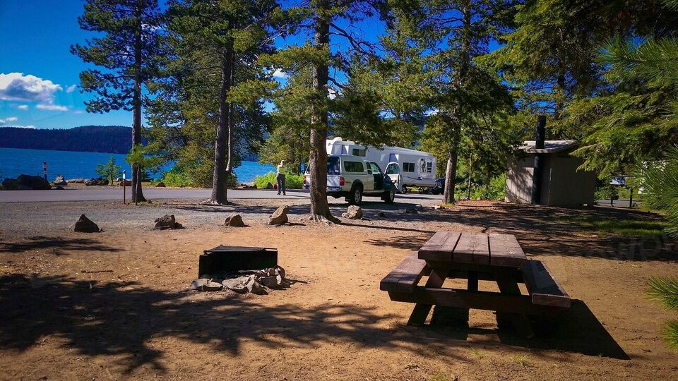 A lakeside campsite with a picnic table