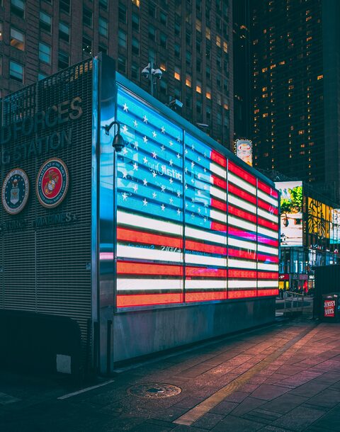 An American flag lit up in neon on a building