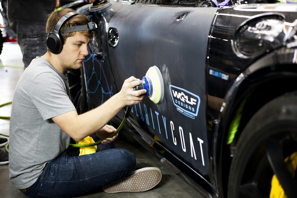 A detailer polishing the side of a car