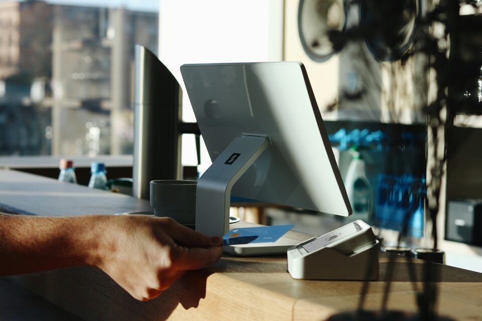 A hand paying at a card terminal
