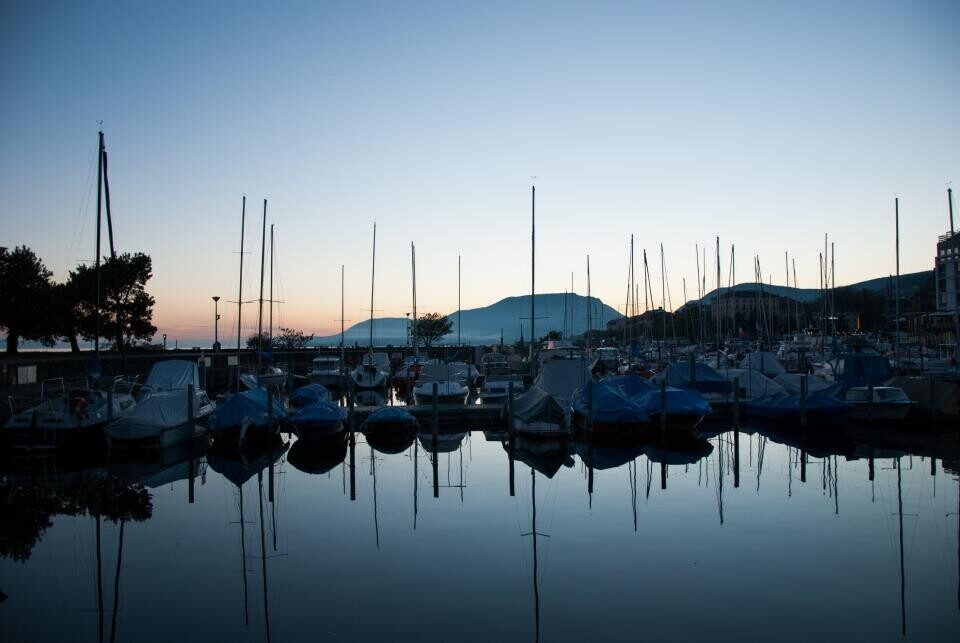 A marina at dusk with masts against the sky