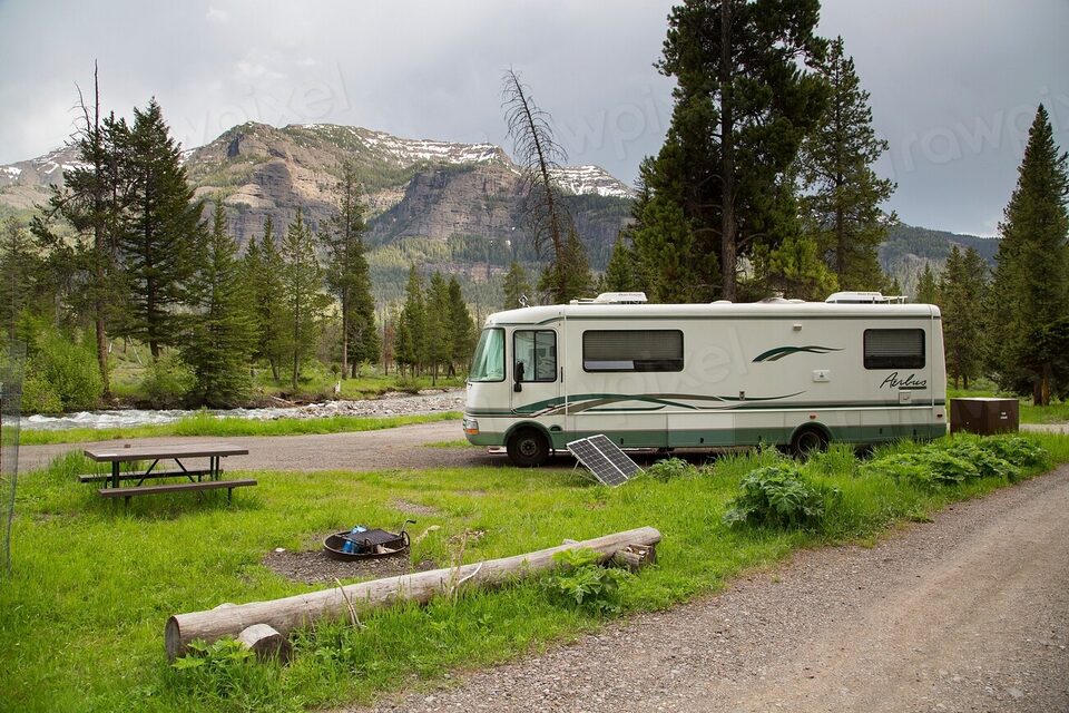 A motorhome at a campground below the mountains