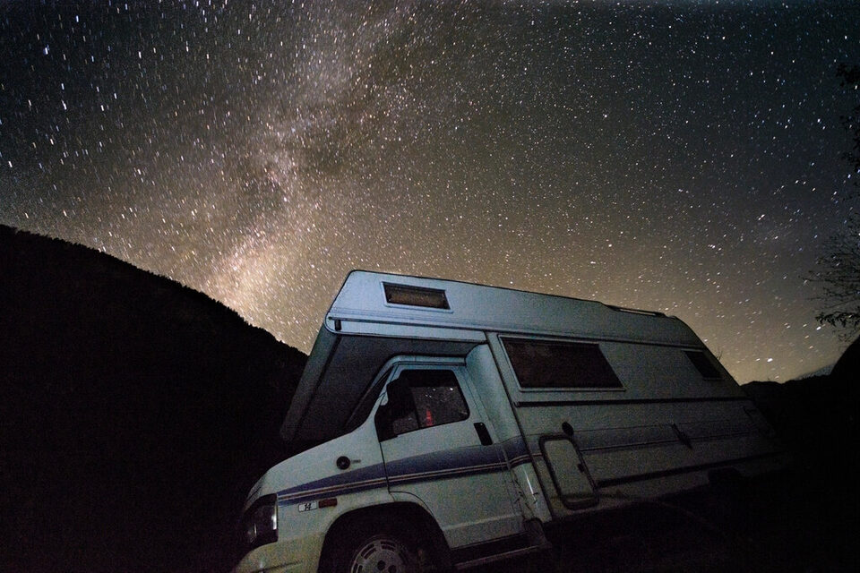 A motorhome beneath a starry night sky