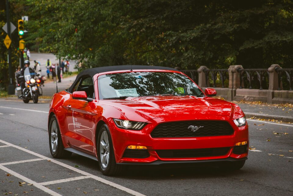 A red convertible driving down a street