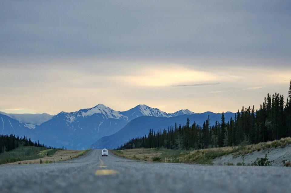 A road leading toward snowy mountains