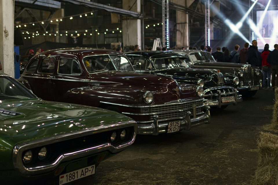 A row of vehicles parked inside a dealership building