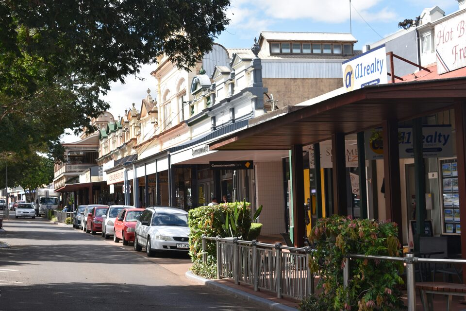 A small-town main street with cars parked outside storefronts