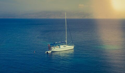 A sailboat anchored on deep blue water