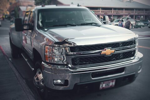 A silver work truck parked at the roadside