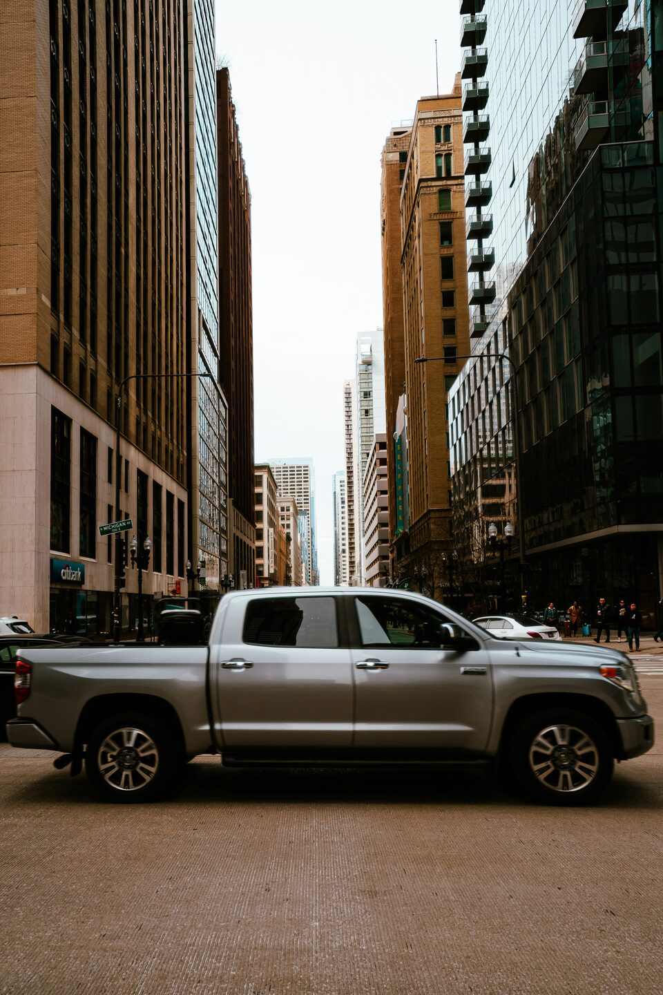 A silver pickup truck on a downtown street