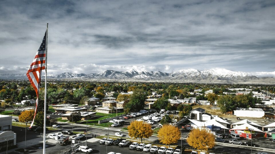 An aerial view of a dealership lot with an American flag flying above it