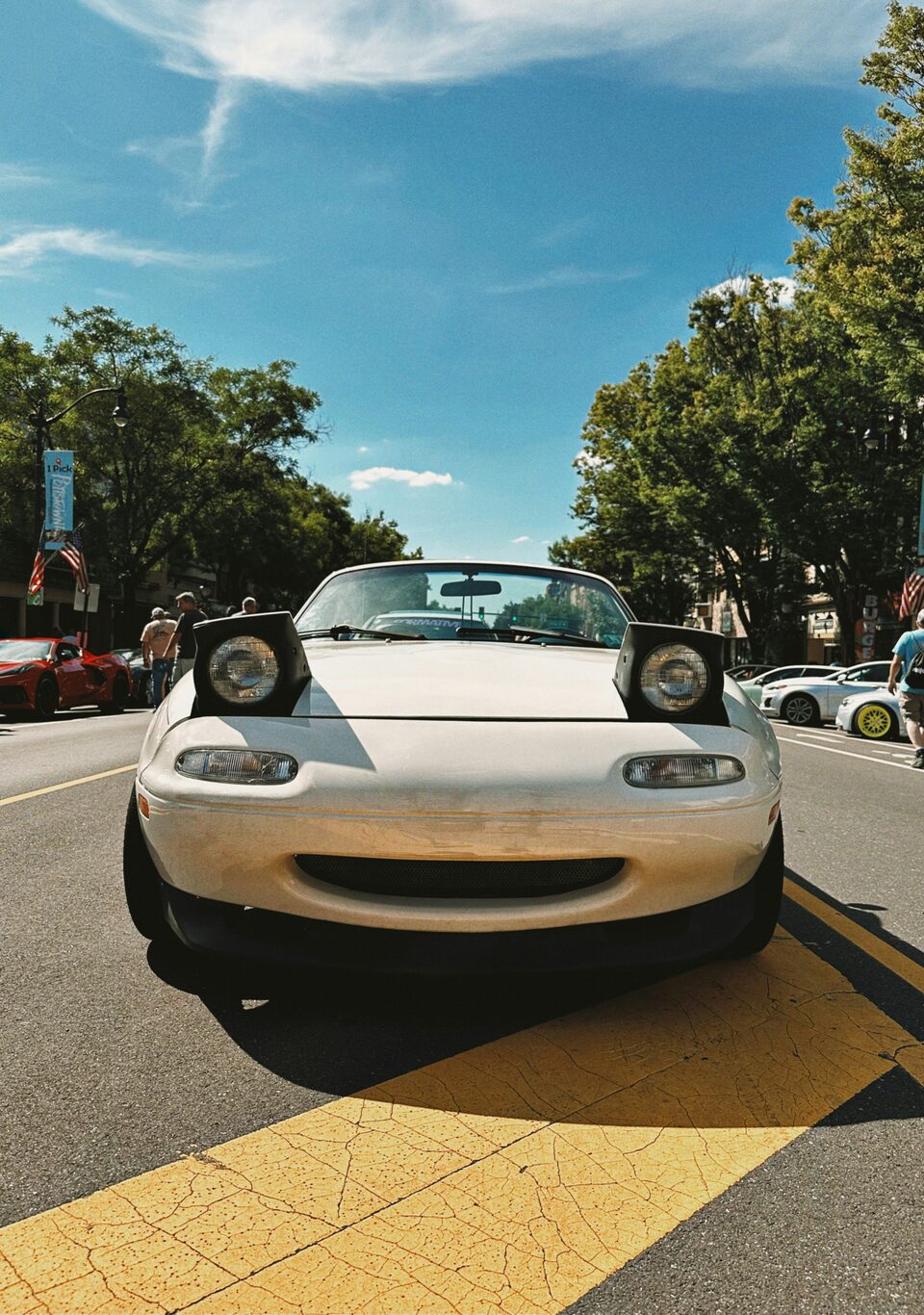 A white Mazda convertible on a sunny street