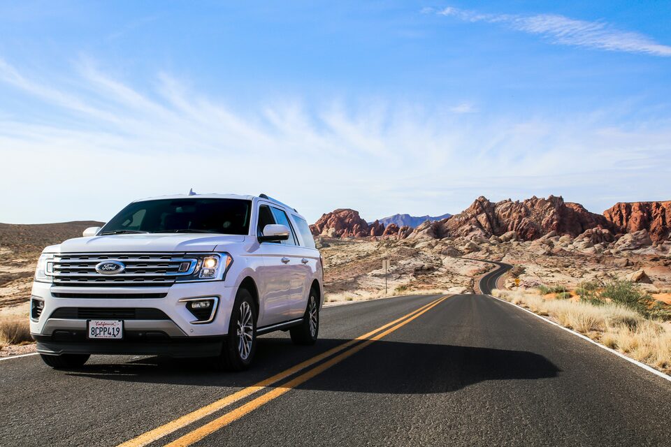 A white SUV on a desert highway