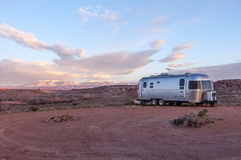 An Airstream trailer in the desert at dusk