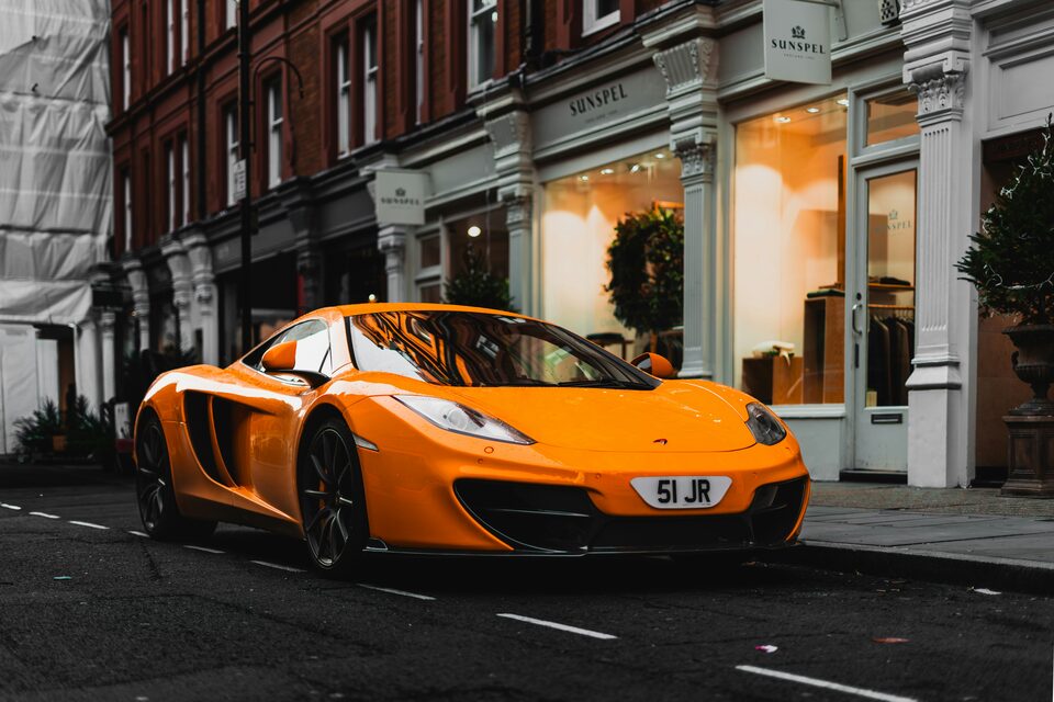 An orange McLaren sports car on a city street