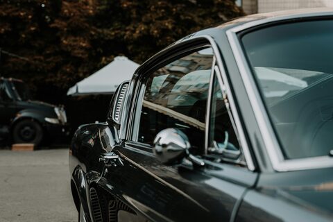 The side of a dark classic car at an outdoor show
