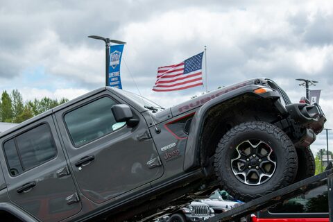 A crew cab pickup truck flying an American flag