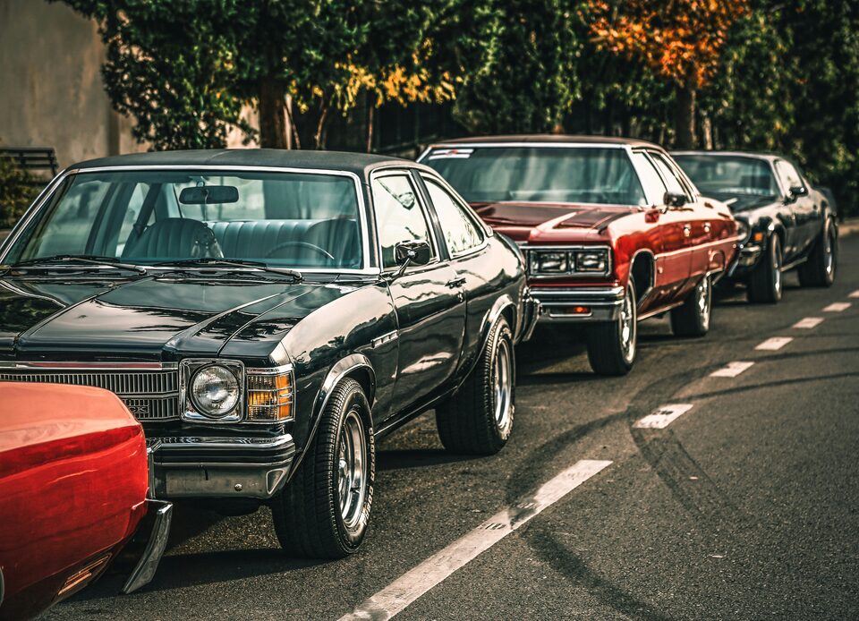 Classic cars parked along a leafy street