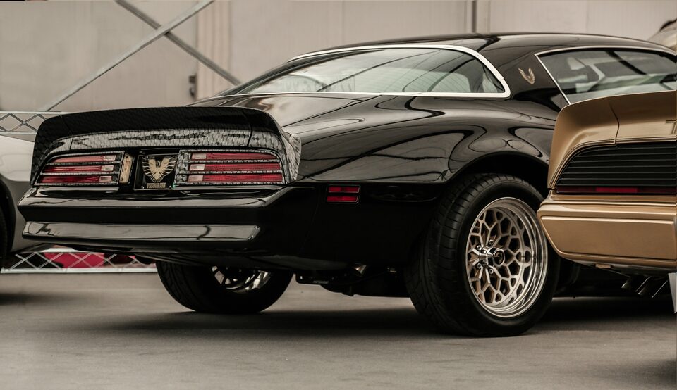 The rear of a black classic Pontiac Trans Am