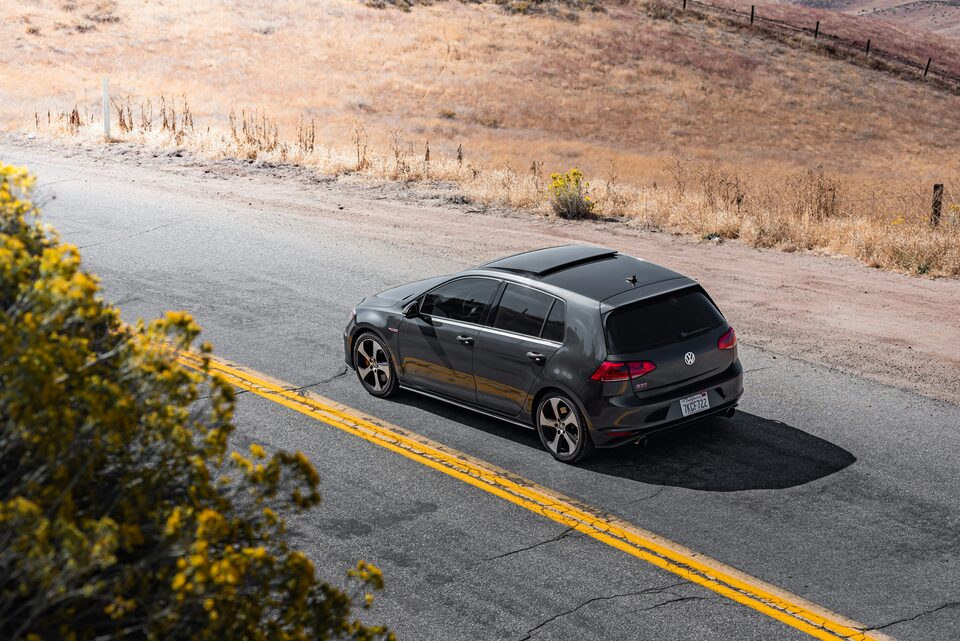 A dark hatchback on a mountain road