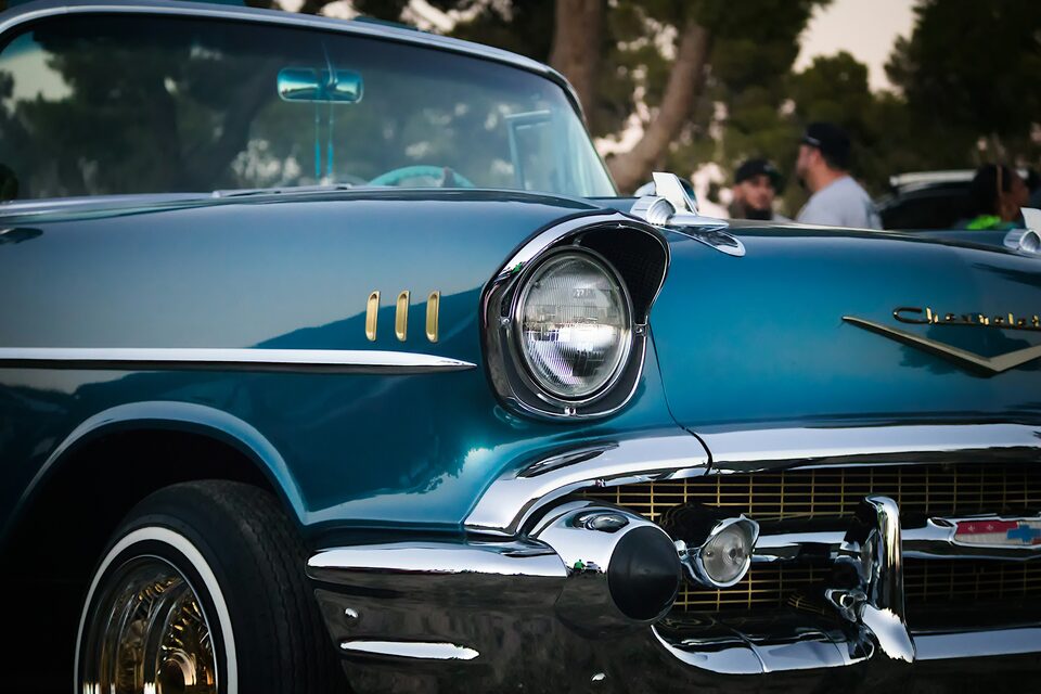 The chrome front of a teal 1957 Chevrolet