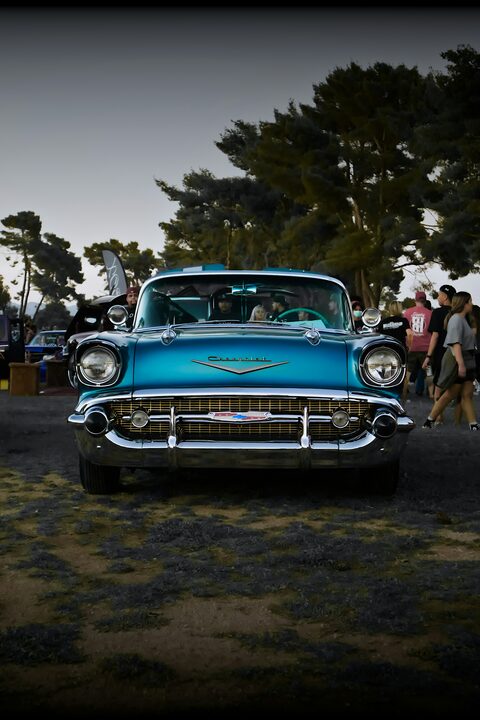 A turquoise 1957 Chevrolet at a car show