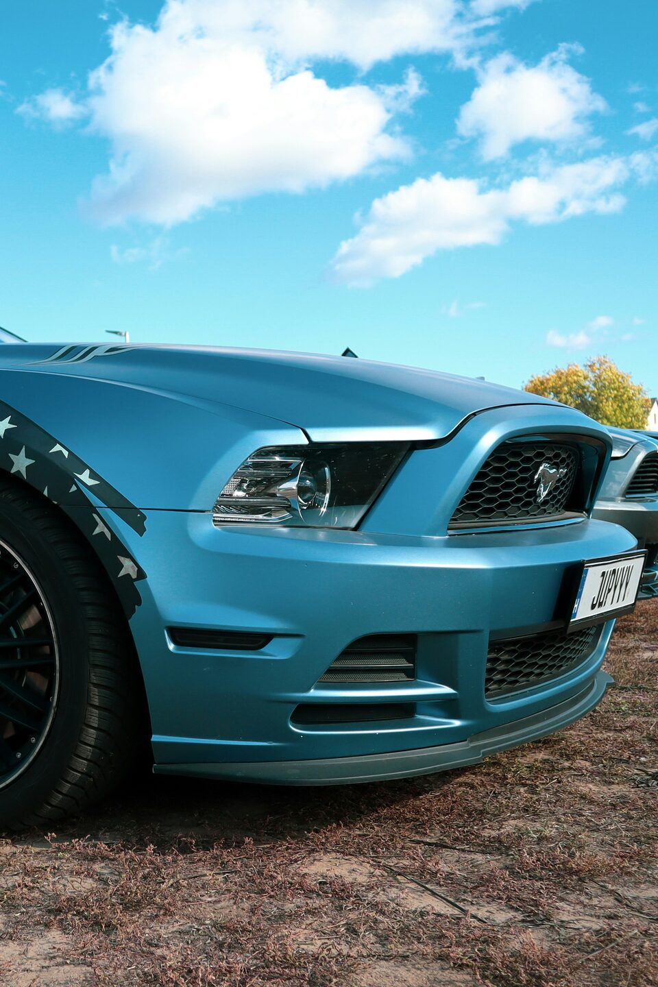The front of a teal Ford Mustang