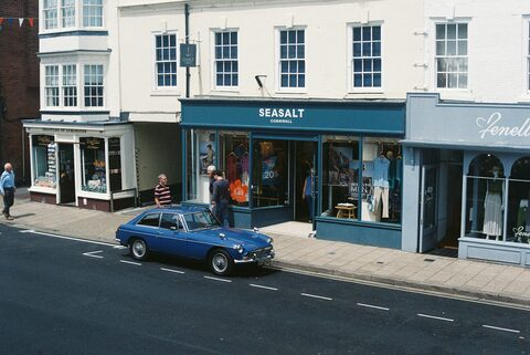 A blue classic sports car on a seaside street