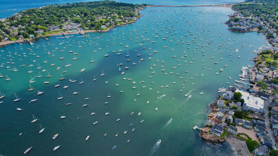 Boats anchored across a sheltered bay from above