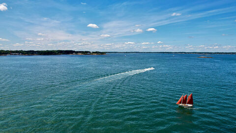 Boats crossing a wide green bay