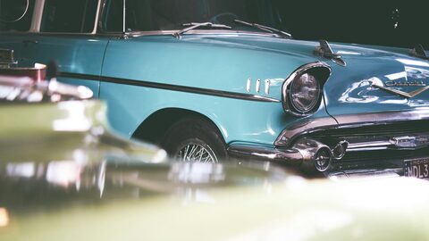 The side of a light blue classic car in soft focus