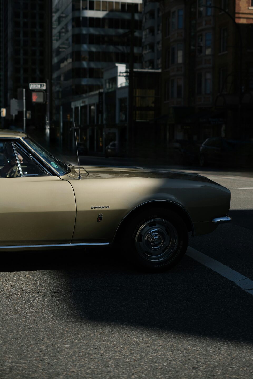 The side of a gold classic Chevrolet Camaro
