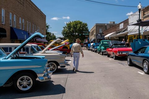 A street car show with classic cars and onlookers