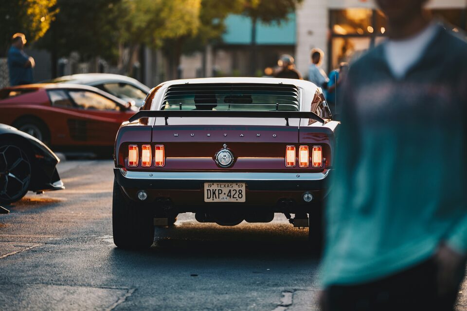 The taillights of a classic Ford Mustang at a car meet