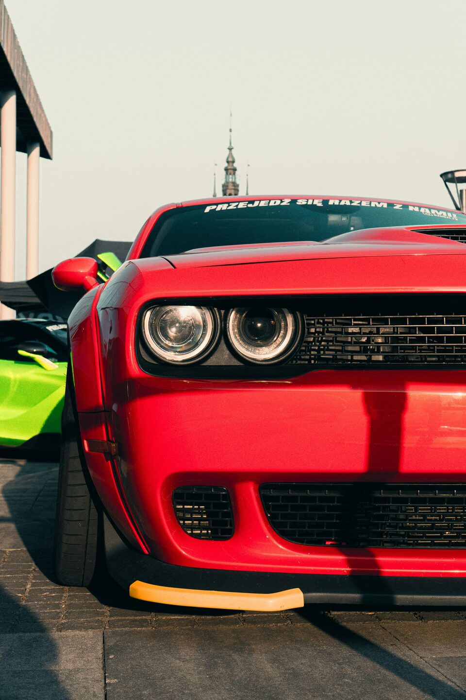 The headlights and grille of a red Dodge Challenger