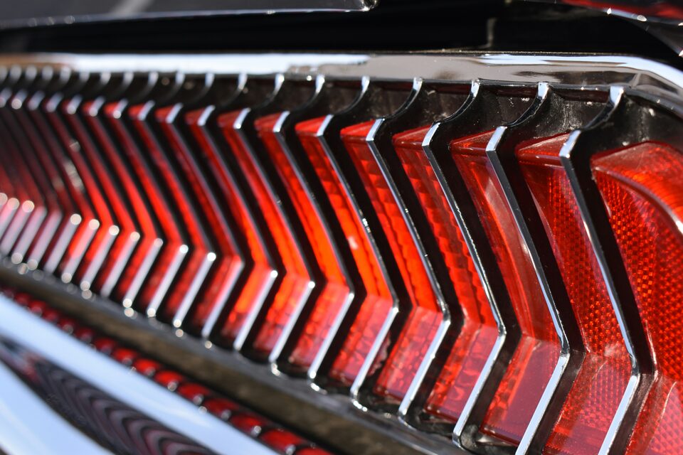 The chrome taillights of a red classic car