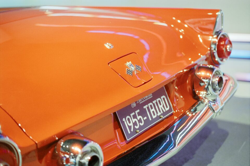 The tail of an orange 1955 Ford Thunderbird