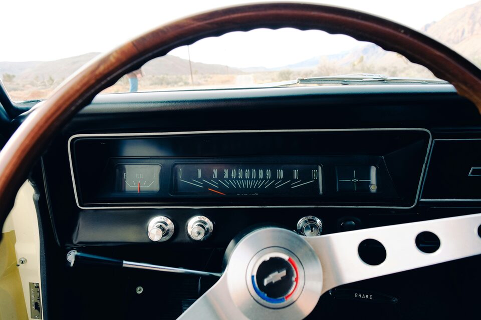 The wood steering wheel and dash of a classic car