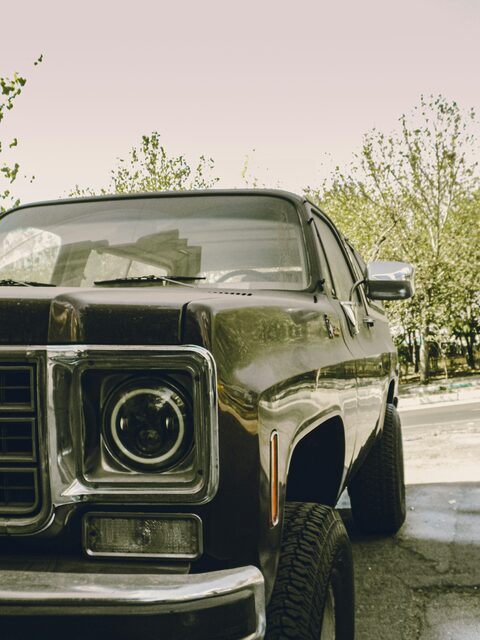 The front of a dark classic pickup truck