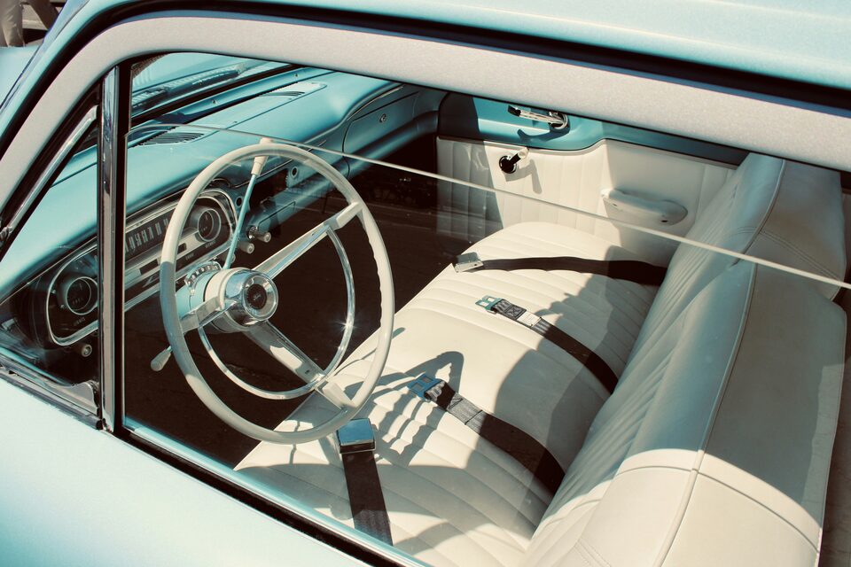 The white interior of a classic car through the open window