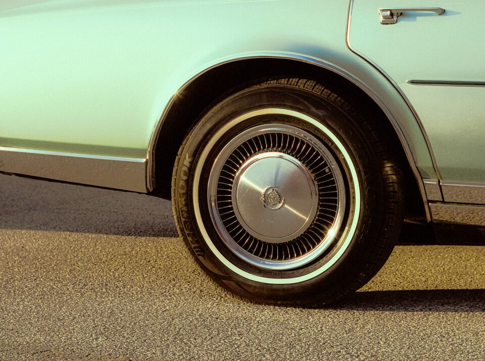 The whitewall wheel of a mint green classic car