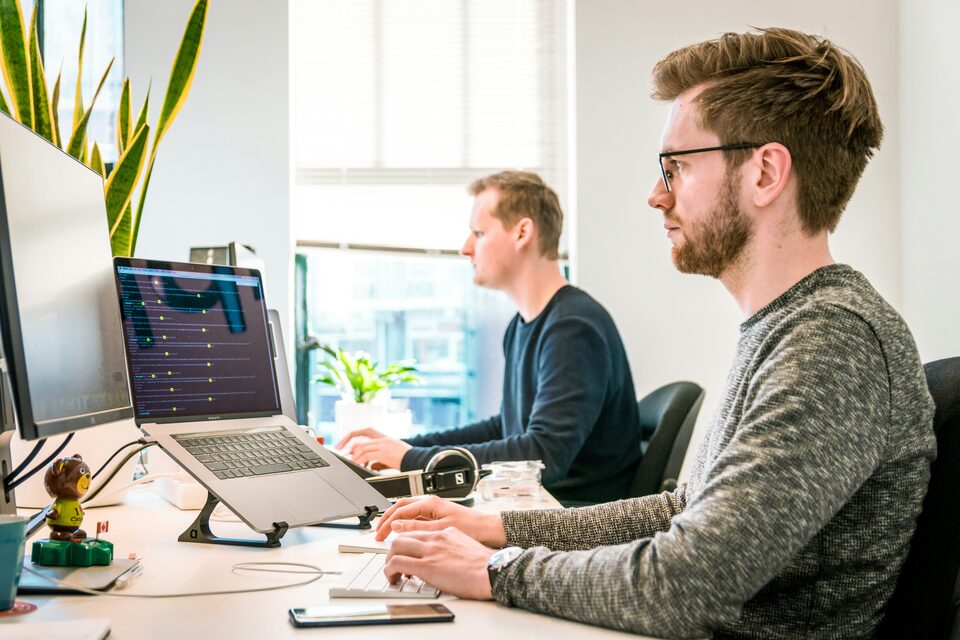 Two people working through paperwork at desks