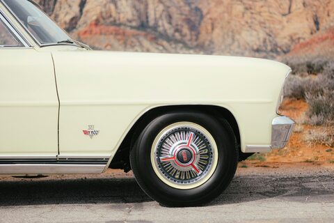 The side of a cream classic car in the desert